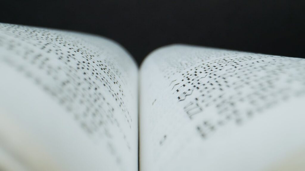 Abstract close-up of an open book's pages in soft focus, highlighting text pattern.